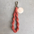 Detail of terracotta macrame keychain with bronze lobster clasp and round wood charm - Spiral Woven Style (With Wood Tag) / Terracotta Red