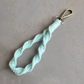 Close-up of sage green spiral woven cotton keychain with bronze metal lobster clasp detail - Spiral Braid Style / Mint Green