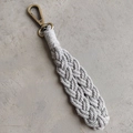 Dettaglio del portachiavi boho intrecciato a mano in corda di cotone con chiusura in bronzo - Stile di base / Grigio chiaro