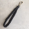 Vue macro d'un porte-clés tressé noir fait main avec fermoir mousqueton en bronze vintage - Noir (5)