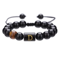 Detail van 10mm zwarte onyx kralen met tijgeroog en gouden letter D bedeltje - Letter D