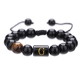 Detalle de cuentas de ágata negra de 10mm y cuenta con letra G dorada en la pulsera ajustable - Letra G