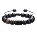 Detalle de pulsera de cuentas de ónix negro de 10mm con cordón trenzado y letra J dorada - Letra J