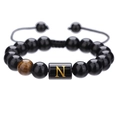 Detalle de pulsera ajustable de cuentas de ónice negro de 10mm con una letra N dorada - Letra N