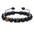Detalle de pulsera trenzada ajustable con cuentas negras de 10mm y letra P dorada tallada - Letra P