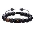 Detalle de cuentas de ónix negro 10mm con ojo de tigre y letra R dorada en cordón ajustable - Letra R