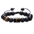 Vista macro de pulsera ajustable de cuentas de ónice negro con ojo de tigre y letra T dorada - Letra T