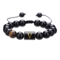 Vista macro de pulsera ajustable de cuentas de ónix negro con pieza de letra V dorada - Letra V