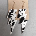 Detalle de pendientes de rayo con textura de vaca sobre soporte de cartón kraft marrón - Estampado de Vaca Negro Blanco (5)