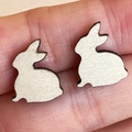 Close-up of cute laser-cut bunny stud earrings with a subtle shimmering finish - White Sitting Rabbit (4)