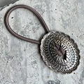 Élastique à cheveux bohème vintage avec breloque ovale en métal sur fond de pierre - Marron