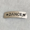 Polished silver metal shoelace charm with DANCE cutout on a textured grey background - DANCE Style (2) / Silver