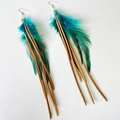 Close-up of bohemian long tassel earrings with turquoise feathers and brown leather cords - Peacock Green (Brown Cord)
