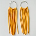 Detail of bright yellow suede fringe earrings with silver hoops in bohemian cowboy style - Yellow