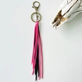 Detalle del llavero de flecos rosa y negro con cierre de bronce y decoración de cráneo - Rosa y Negro