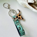 Macro detail of western leather keychain with leopard cow skull and embossed leather - Classic Leopard Bull Head