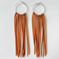 Detail of bohemian orange-brown suede fringe earrings with silver-tone metal hoops - Caramel