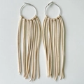Detail of silver hoop earrings featuring soft beige leather fringe tassels and fine texture - Beige