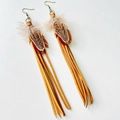 Detail of bohemian feather earrings featuring brown leather fringe and bronze metal hooks - Brown