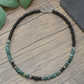 Beaded necklace with black agate and blue spotted stones on a rustic wood background - Glossy Black Bead Spliced with Grey Green Stone Style (ZJ13703)
