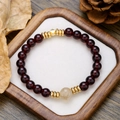 Dettaglio del bracciale di perle in granato con distanziatori dorati su sfondo in legno - Stile Distanziatori Metallici Dorati Agata Con Granato (ZJ13607)
