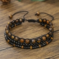 Bracciale intrecciato a tre strati in occhio di tigre e onice per uomo su fondo legno - Stile Impilabile Occhio di Tigre a Tre Strati (ZJ14048)
