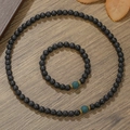 Handgefertigtes Set aus schwarzen Lavastein-Perlenketten und Armbändern auf Holzhintergrund - Schwarzer Lavastein Stil (ZJ14077) / Andere