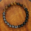 Tijgeroog en obsidiaan kralenarmband met metalen tussenstukken op houten achtergrond - Tijgeroog Obsidiaan (ZJ14068)