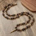 Vintage Perlenkette mit Holzperlen und einem goldenen Nietanhänger auf Holzgrund - Vintage Holzperlen Goldene Spike Anhänger Kette (ZJ14196)