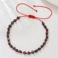 Detail van rode gevlochten armband met matzwarte kubuskralen en verstelbare sluiting - Rood Touw Zwarte Geometrische Vierkante Kralen Stijl (ZJ15084)