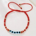 Detail van rode kralenarmband met boze oog bedeltjes en verstelbaar trekkoord - Rood Touw Vijf Boze Ogen Stijl (ZJ15081)