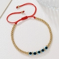 Detail van rode gevlochten armband met gouden kralen en blauwe evil eye bedeltjes - Rood Touw Gouden Kralen Boze Oog Stijl (ZJ15082)