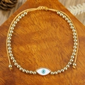Detail van verstelbare boze oog armband met gouden kralen en emaille bedel op hout - Witte Wimpers Boze Oog Stijl (ZJ15145)
