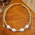 Macro-opname van gevlochten armband met gouden kralen en witte getextureerde kralen - Gouden Kralen Witte Onregelmatige Kralen Stijl (ZJ15144)
