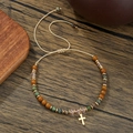 Detail van kralenarmband met stenen kralen en een gouden kruishanger - Beige Touw Kruis Hanger Stijl (ZJ14825)