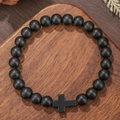 Matte zwarte kralenarmband met kruishanger op rustieke donkere houten ondergrond - Mat Zwart Stijl (ZJ14082)