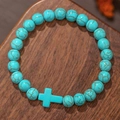 Heren kralenarmband van turkoois met kruishanger op een natuurlijke donkerhouten ondergrond - Turkoois Textuur Stijl (ZJ13822)