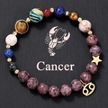 Macro shot of Cancer zodiac natural stone bead bracelet with golden star and coin charms - Cancer