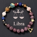 Macro view of natural stone Libra bracelet with golden constellation and star pendants - Libra