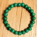 Bracciale unisex in perline di malachite con venature verdi su superficie di legno - Stile Malachite 8mm (8mmZJ15815)