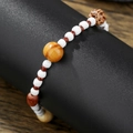 Close-up of beaded bracelet with wood, agate and coconut shells on a black display stand - White Round Bead Wood Grain Style (ZJ14821)