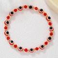 Detail van rode gefacetteerde kristallen armband met evil eye kraal en gouden tussenstukjes - Rode Gefacetteerde Kralen & Boze Oog Stijl (ZJ15037)