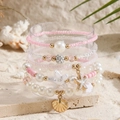 Summer bohemian bead bracelet set with starfish and seashell charms on beach sand - Ocean Theme Pink Pearl Layered Style (ZJ14933)