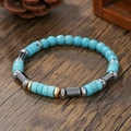 Detail van herenarmband met turquoise kralen en hematiet op donker houtoppervlak - ZJ14262-Turkoois Hematiet Metaal Afstandhouder Armband