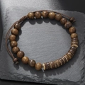 Detalle de pulsera de cuentas de madera con piezas de coco sobre piedra negra - Estilo de Cordón Trenzado de Madera Marrón Oscuro (ZJ12523)