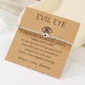 Detail of silver CCB beaded Evil Eye bracelet on a kraft display card for gifts - Deep Blue (ZJ15630)