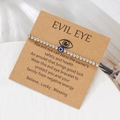 Silver beaded Evil Eye friendship bracelet on brown display card with symbolic meaning - White (ZJ15634)