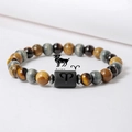 Detalle de la pulsera Aries con ojo de tigre y piedras naturales sobre fondo blanco - Aries (ZJ15812)