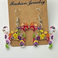 Detailed close-up of colorful floral dog silhouette earrings on kraft card - Floral Dog Style