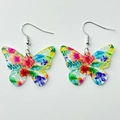 Detailed view of butterfly-shaped acrylic earrings with vibrant floral print and silver hooks - Butterfly Flower Style